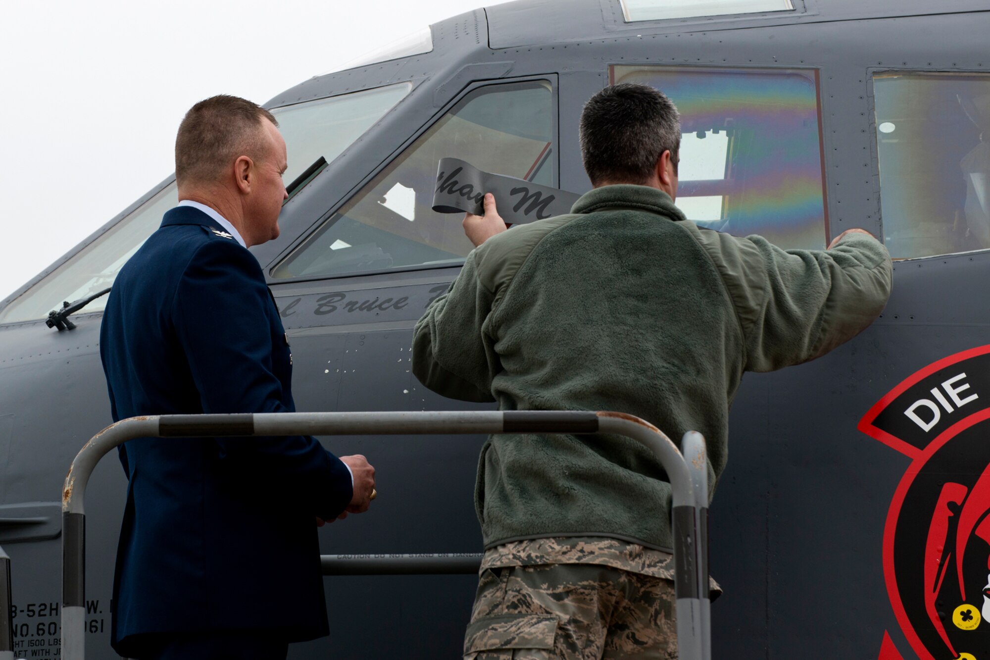 U.S. Air Force Col. Bruce Cox watches as his name is unveiled on the side of a 307th Bomb Wing B-52H Stratofortress following a Change of Command ceremony, Dec. 7, 2014, Barksdale Air Force Base, La. Cox is the former Director of Operations and Plans Directorate, 10th Air Force, and took command of the 307th Bomb Wing during the ceremony. (U.S. Air Force photo by Master Sgt. Greg Steele/Released)