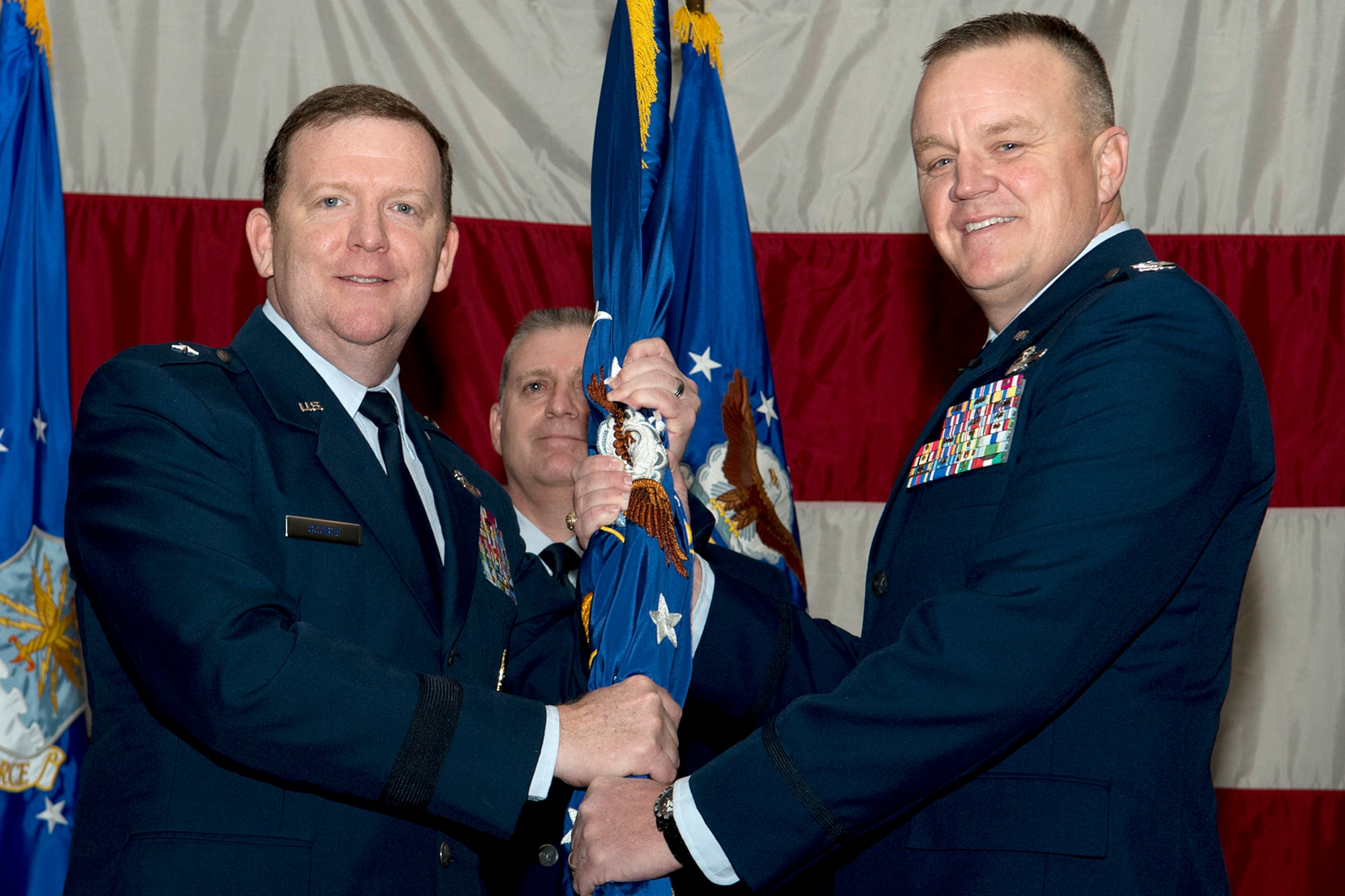 U.S. Air Force Brig. Gen. Richard Scobee (left), 10th Air Force commander, presents the 307th Bomb Wing flag to Col. Bruce Cox during a Change of Command ceremony, Dec. 7, 2014, Barksdale Air Force Base, La. Cox is the former Director of Operations and Plans Directorate, 10th Air Force, and took command of the 307th Bomb Wing during the ceremony. (U.S. Air Force photo by Master Sgt. Greg Steele/Released)