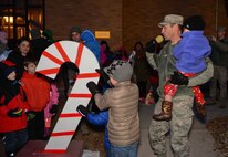 Col. Kevin Kennedy, 28th Bomb Wing commander, and children of deployed Ellsworth Airmen flip the switch to light the base Christmas tree during the 28th BW Tree Lighting Ceremony at the Freedom Chapel on Ellsworth Air Force Base, S.D., Dec. 3, 2014. Airmen and their families gathered for the event that kicked off the holiday season. (U.S. Air Force photo by Senior Airman Zachary Hada/Released)