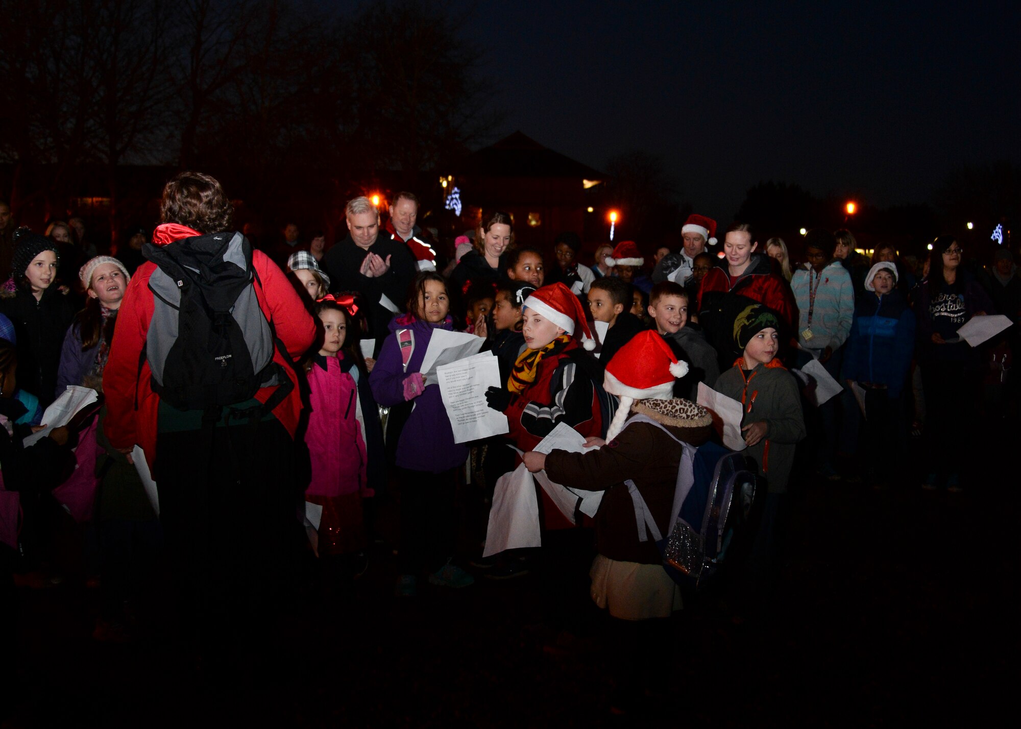 Children enrolled in RAF Mildenhall's youth programs sing Christmas carols during the base's annual Christmas tree lighting ceremony Dec. 5, 2014, on RAF Mildenhall, England. The event kicked off the holiday season for Team Mildenhall families.  (U.S. Air Force photo by Senior Airman Victoria H. Taylor/Released)