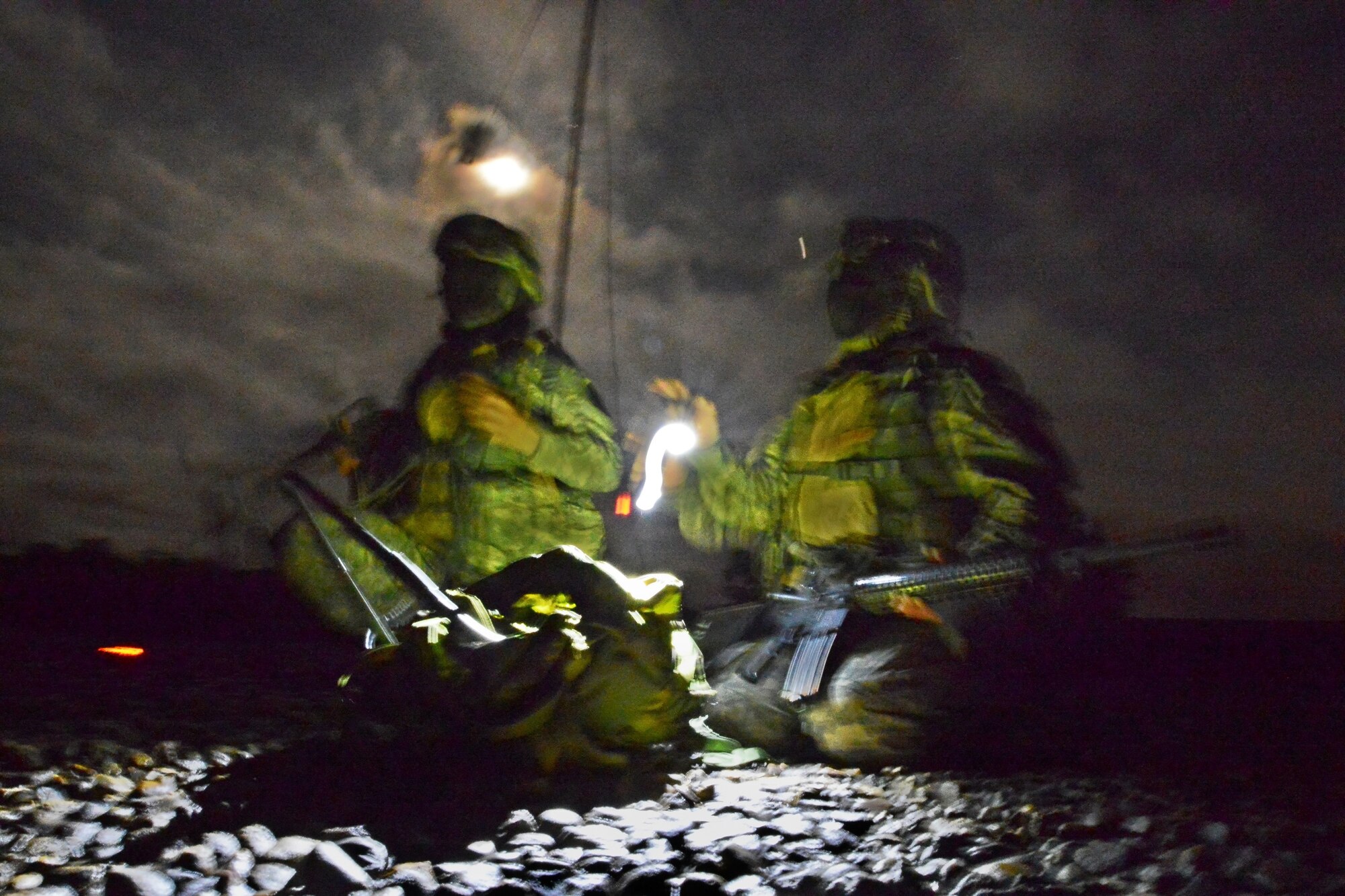 BUTLERVILLE, Ind. - Two soldiers setup rooftop communications during a simulated night attack during blackout conditions at the Muscatatuck Urban Warfare Training Center June 10, 2014. The soldiers took to the roof after the building they were operating in was attacked using simulated gas warfare. (U.S. Air Force photo/Tech. Sgt. Frank Oliver)