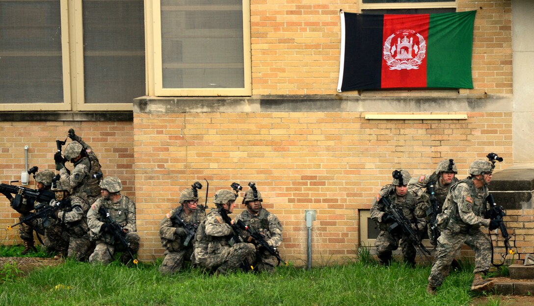 BUTLERVILLE, Ind. - Army Infantry soldiers shoot, move and communicate as they train on urban combat techniques at the Muscatatuck Urban Warfare Training Center June 10, 2014. The realistic setup helps troops learn to perform at a high level for dealing with fighting within Middle Eastern cities. (U.S. Air Force photo/Tech. Sgt. Frank Oliver)