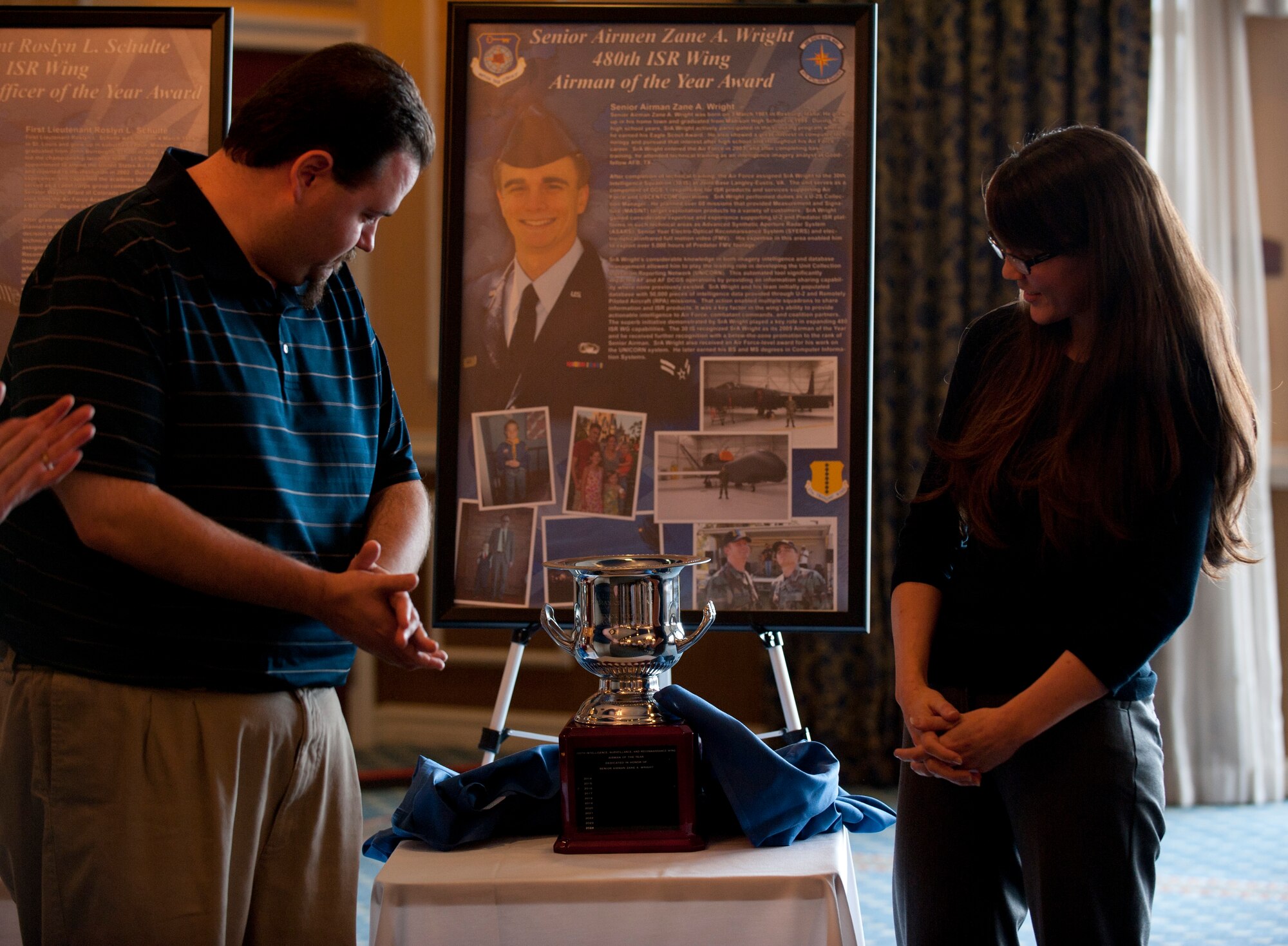 Victoria Wright, wife of Senior Airman Zane Wright, looks at the annual award dedicated in his honor at the 480th Intelligence, Surveillance and Reconnaissance Wing Heritage Observance and Awards Dedication ceremony at Langley Air Force Base, Va., Dec. 4, 2014. Wright was an intelligence analyst with the 480th ISR Wing, who lost his battle with cancer two years ago. He was recognized for his contributions to the wing including the Unified Collections Operations Reporting Network, or UNICORN program. (U.S. Air Force photo by Staff Sgt. Natasha Stannard/Released)