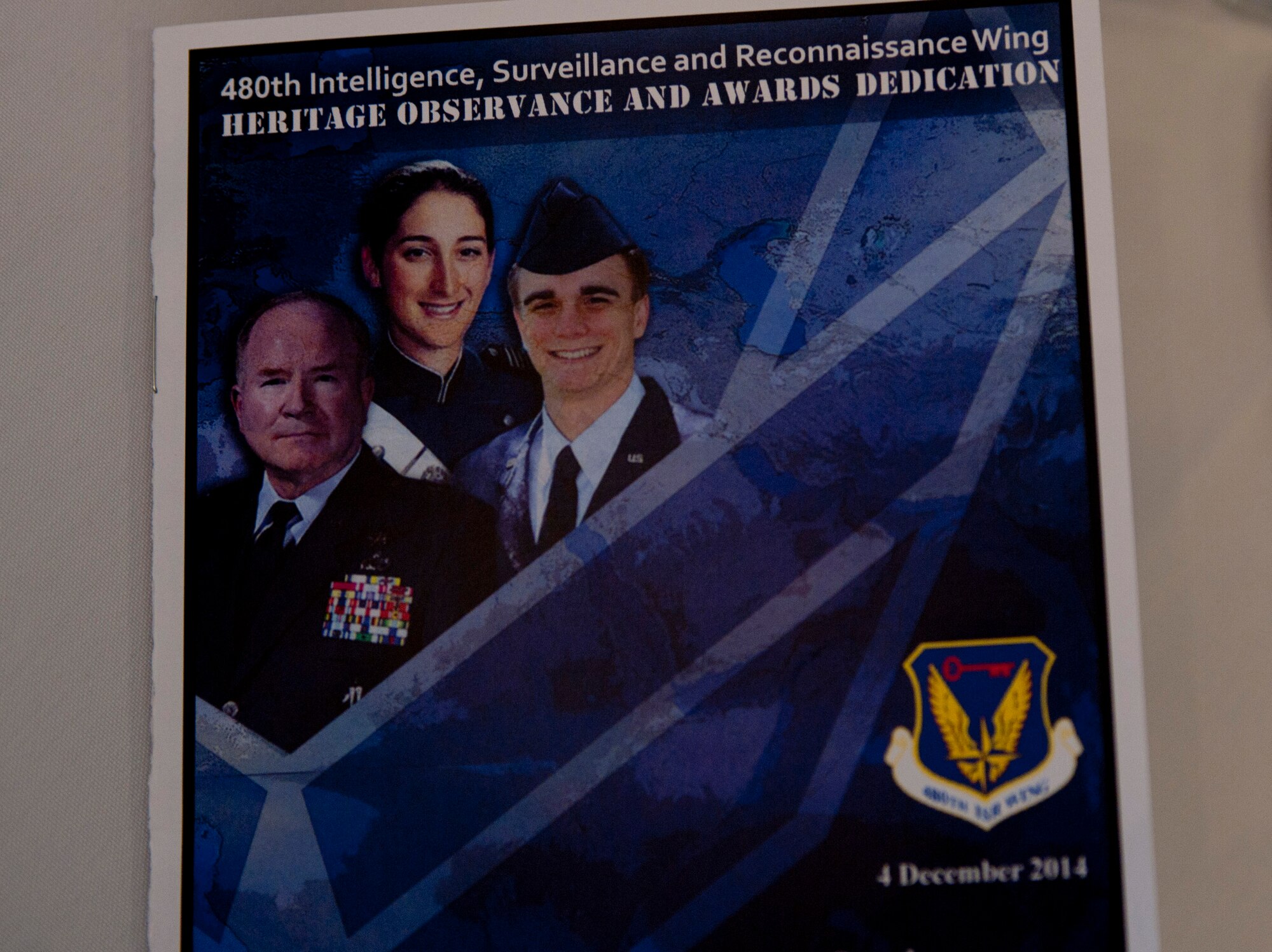 A Heritage Observance and Awards Dedication ceremony pamphlet sits on a table at the luncheon for the ceremony at Langley Air Force Base, Va., Dec. 4, 2014. The ceremony recognized three former 480th Intelligence, Surveillance and Reconnaissance Wing  members and their contributions to the ISR mission by unveiling annual awards named in their honor. (U.S. Air Force photo by Staff Sgt. Natasha Stannard/Released)