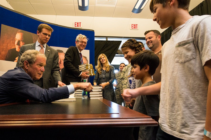 The Honorable George W. Bush, 43rd President of the United States, fist bumps Team Moody members during his book signing Dec. 4, 2014, at Moody Air Force Base, Ga. Bush visited Moody’s base exchange for a book signing and personally greeted more than 800 Department of Defense ID cardholders. (U.S. Air Force photo by Airman 1st Class Ceaira Tinsley/Released)