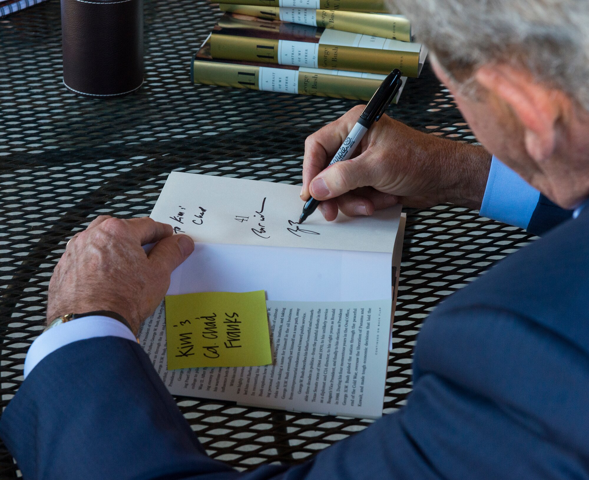 The Honorable George W. Bush, 43rd President of the United States, autographs the first book during a book signing Dec. 4, 2014, at Moody Air Force Base, Ga. Bush autographed more than 800 books for Department of Defense ID cardholders during his trip to Valdosta, Ga. (U.S. Air Force photo by Airman 1st Class Ceaira Tinsley/Released)