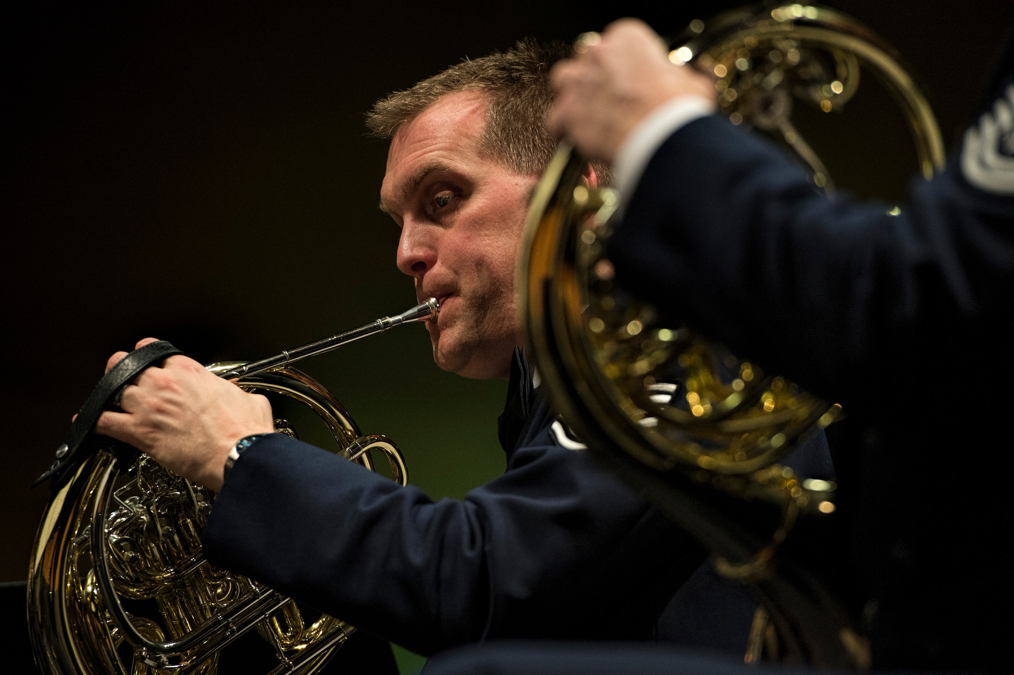 U.S. Air Force Tech. Sgt. Peter Dahlstrom, U.S. Air Forces in Europe Band French horn player from Columbus, Ohio, plays the French horn during a holiday concert in Bitburg, Germany, Dec. 6, 2014. Four local choirs performed holiday music throughout the event as well. (U.S. Air Force photo by Staff Sgt. Christopher Ruano/Released)