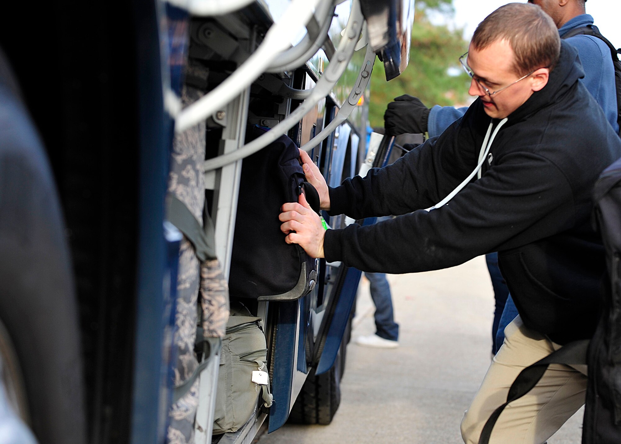 A U.S. Service member packs his luggage in the bus after leaving the Langley Transit Center at Langley Air Force Base, Va., Dec. 4, 2014. The 633rd Air Base Wing established the center as a controlled monitoring area to house members returning from Operation United Assistance missions in West Africa. (U.S. Air Force photo by Airman 1st Class Breonna Veal/ Released)