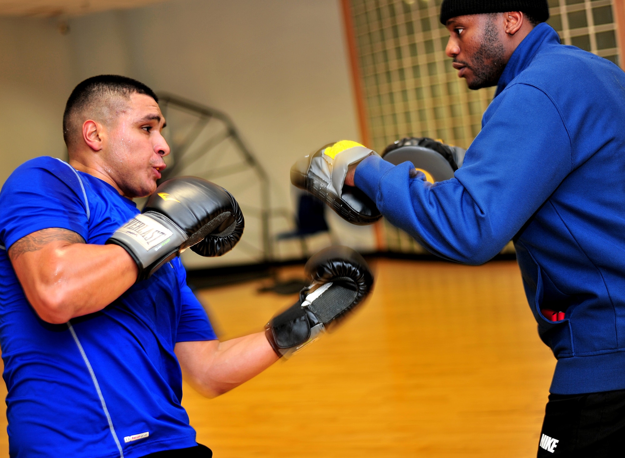 U.S. Air Force Senior Airman Oscar Campos-Ortiz, 100th Communications Squadron postal clerk from Dallas, throws an upper cut at U.S. Air Force Tech. Sgt. Duane Vandross, 100th Communications Squadron installation spectrum manager from Bronx, N.Y., during a boxing training session Oct. 9, 2014, at the RAF Lakenheath Fitness Center. Vandross and U.S. Air Force Capt. Sean Mitchell, 100th Operations Support Squadron chief of wing scheduling from Montgomery, Ala., established a boxing team at RAF Mildenhall May 2013. (U.S. Air Force photo by Senior Airman Christine Griffiths/Released)