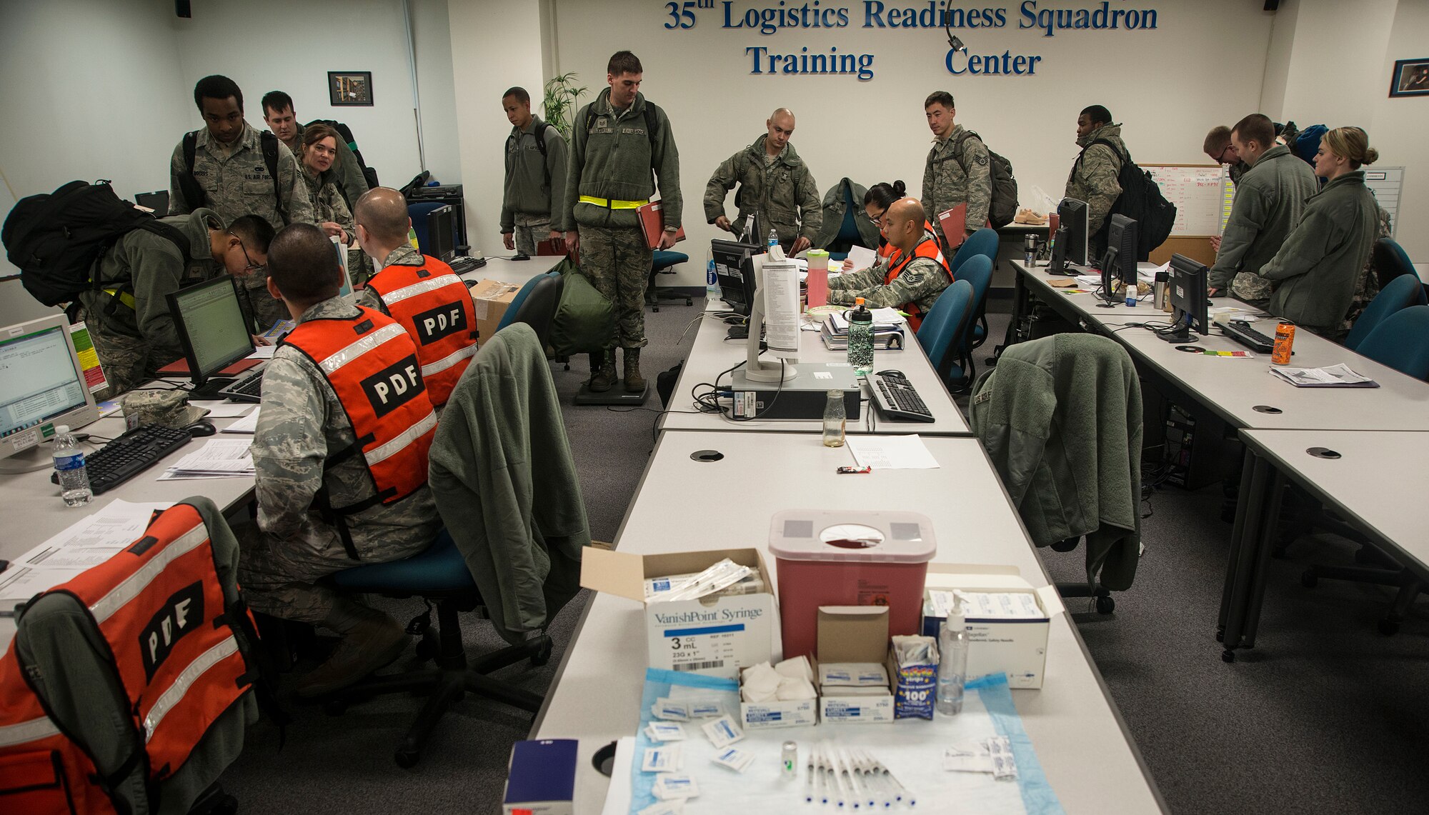 Airmen process through the personnel deployment function line at the 35th Logistics Readiness Squadron at Misawa Air Base, Japan, Dec. 8, 2014. During their walk through the PDF line, Airmen will have their deployment folders reviewed and personal documents like finances and wills processed before forward deploying. (U.S. Air Force photo by Staff Sgt. Derek VanHorn/Released)