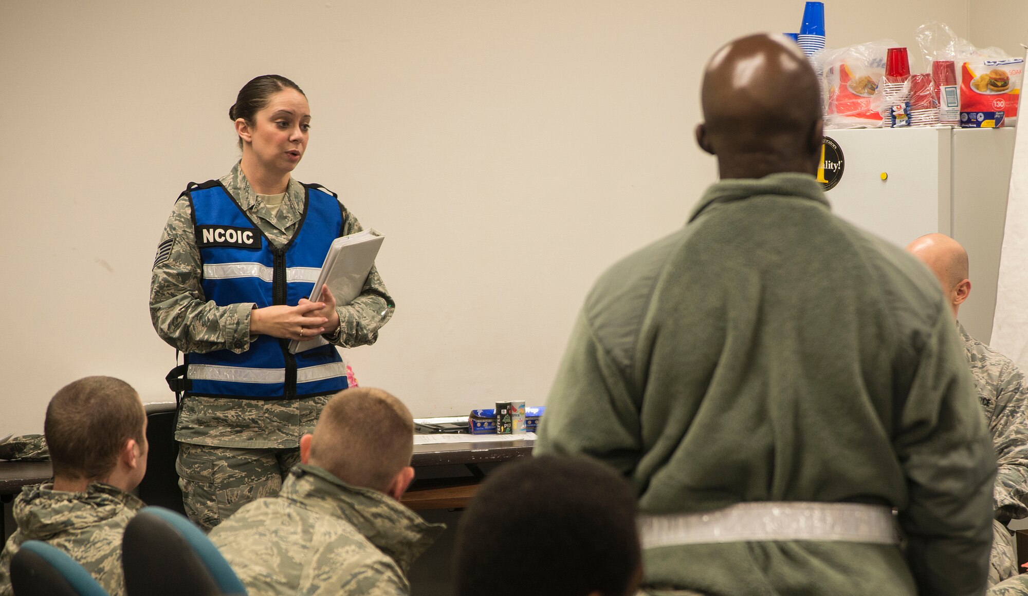 Air Force Tech. Sgt. Lindsay Matthews, 35th Force Support Squadron section chief of customer support briefs in-processing Airmen at Misawa Air Base, Japan, Dec. 5, 2014. Matthews and her team simulated a reception processing unit for Airmen from other bases in the Pacific region for exercise Beverly Sunrise 15-1, a revamped way of exercising real-world scenarios. (U.S. Air Force photo by Staff Sgt. Derek VanHorn/Released)