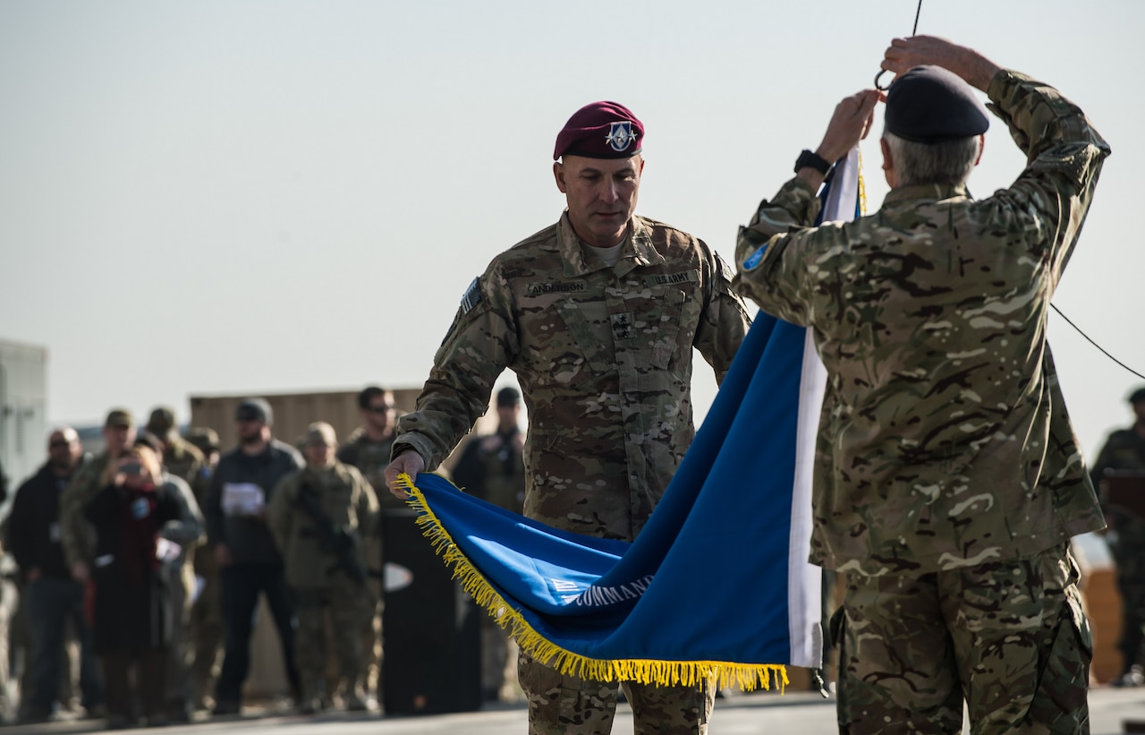 Army Lt. Gen. Joseph Anderson, commander of International Security Assistance Force Joint Command, and Royal Army Maj. Gen. Richard Nugee, ISAF chief of staff, lower the ISAF Joint Command colors at Kabul International Airport, Afghanistan, during a casing ceremony marking the end of the ISAF Joint Command mission, Dec. 8, 2014 U.S. Air Force photo by Staff Sgt. Perry Aston