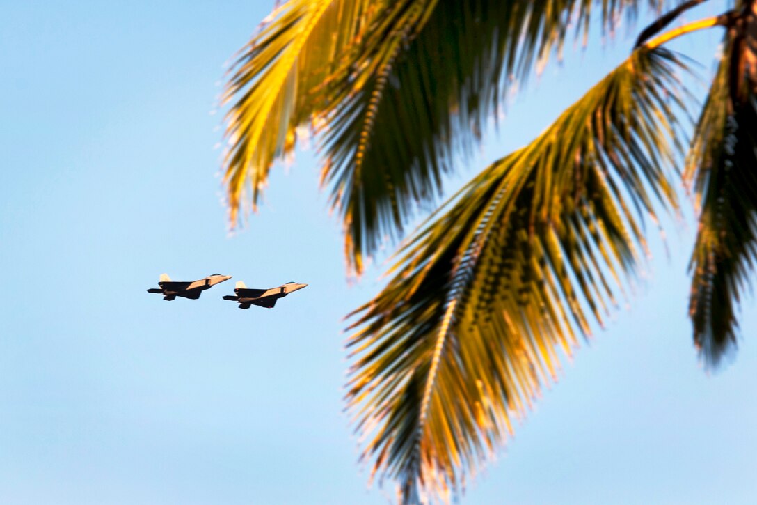 Two F-22 Raptors, assigned to the 199th Fighter Squadron, Hawaii Air National Guard, 19th Fighter Squadron, U.S. Air Force, conduct a flyover during the 73rd Anniversary Pearl Harbor Day commemoration ceremony at the Pearl Harbor Visitor Center  in Pearl Harbor, Hawaii, Dec. 7, 2014. 