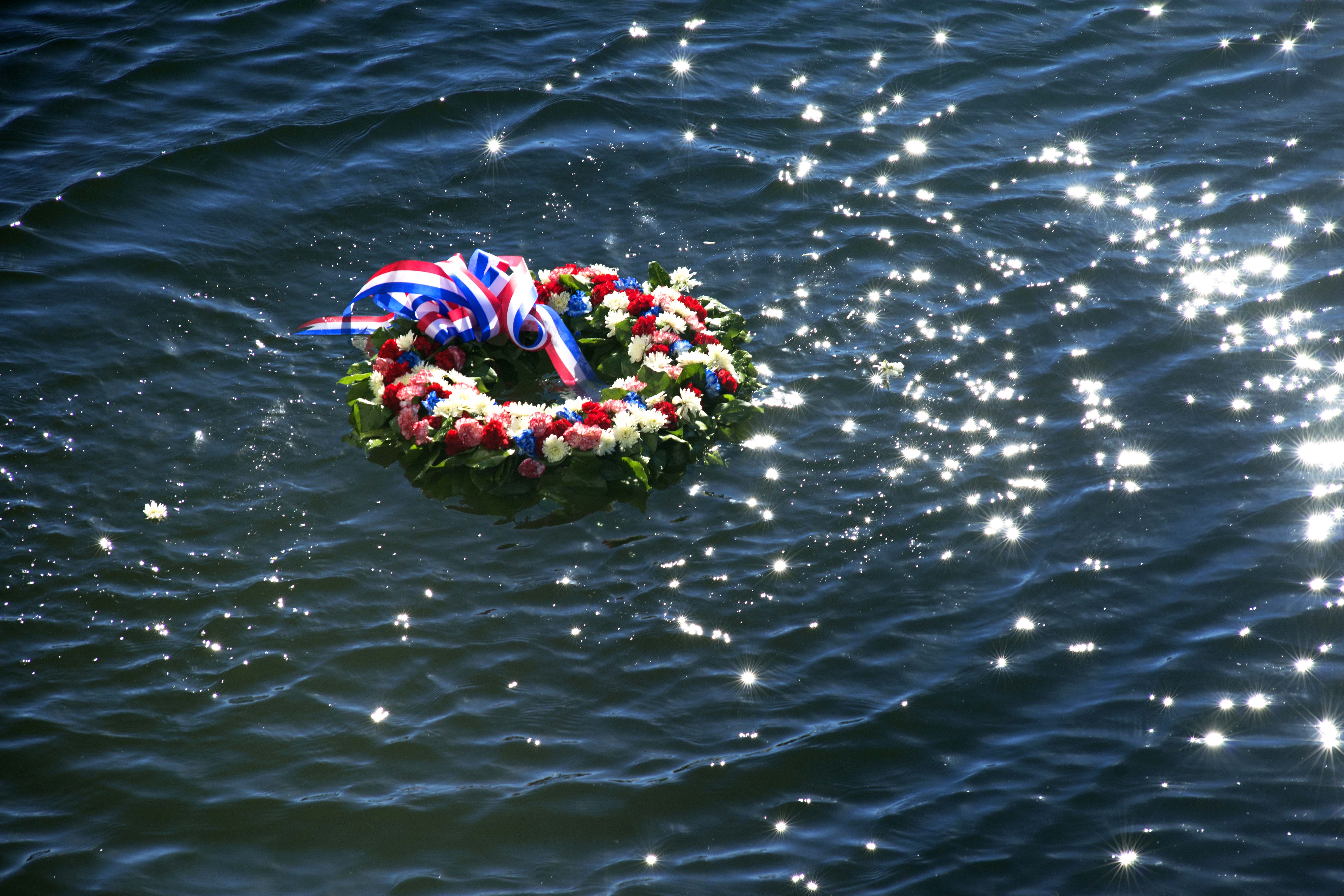 A floral wreath is placed in the water to memorialize the lives lost during the attacks on Pearl