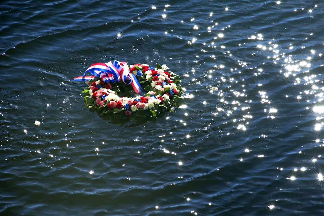 A floral wreath is placed in the water to memorialize the lives lost during the attacks on Pearl Harbor, Hawaii, during a memorial ceremony held aboard the Coast Guard Cutter Taney in Baltimore, Dec. 7, 2014. 