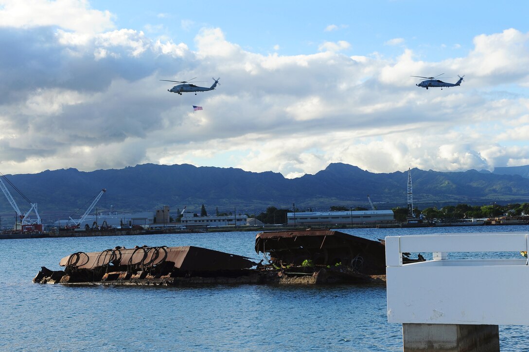 Navy helicopters fly an American flag over the USS Utah Memorial on Pearl Harbor, Hawaii, Dec7, 2014, during an ash scattering ceremony held in honor of Pearl Harbor attacks survivor Navy Petty Officer 2nd Class Harvey E. Smith.