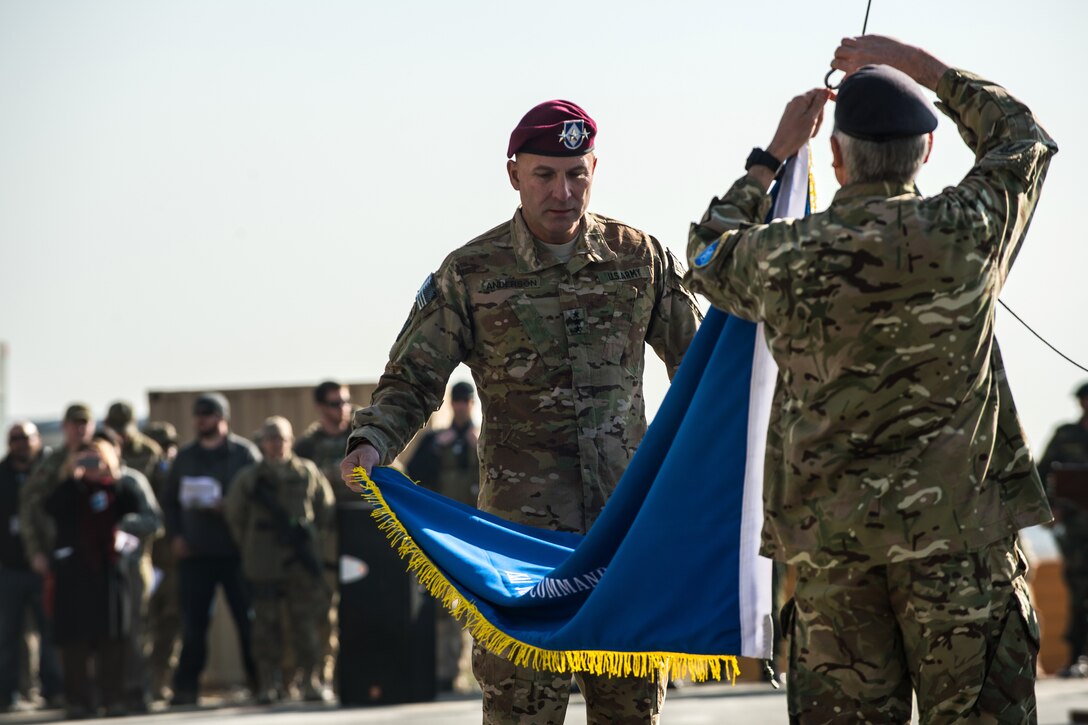 U.S. Army Lt. Gen. Joseph Anderson, commander of International Security Assistance Force Joint Command, and British Army Maj. Gen. Richard Nugee, ISAF chief of staff, lower the ISAF Joint Command colors during the command's end-of-mission ceremony on North Kabul International Airport in Afghanistan, Dec. 8, 2014.