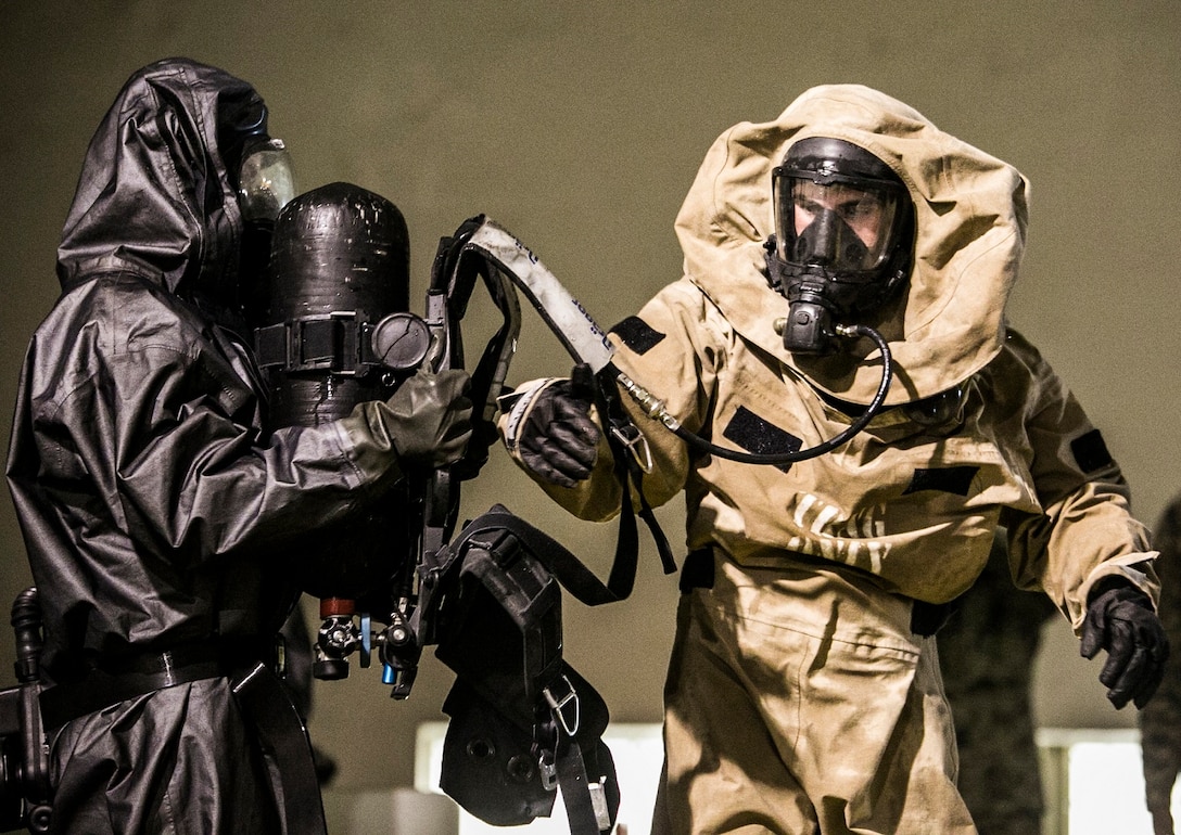 Lance Cpl. Kevin A. Mckinzie, right, and Cpl. Peter L. Filipowicz, both chemical, biological, radiological and nuclear defense specialists, demonstrate the decontamination process while wearing mission oriented protective posture gear Dec. 1 at Camp Kinser. The demonstration was for members of the Japan Ground Self-Defense Force to view the Marines’ CBRN defense capabilities. Mckinzie, from Palm Harbor, Florida, is with Headquarters Regiment, 3rd Marine Logistics Group, III Marine Expeditionary Force. Filipowicz, from Bradenton, Florida, is with Marine Wing Headquarters Squadron 1, 1st Marine Aircraft Wing, III MEF. 
