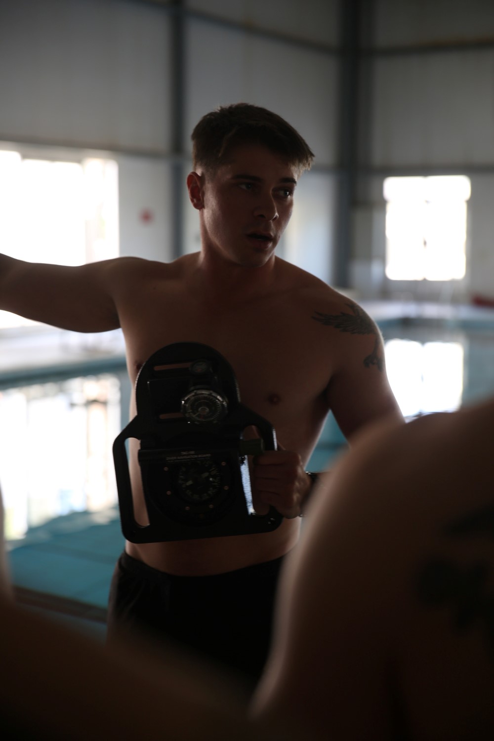 A Marine with the reconnaissance detachment, 11th Marine Expeditionary Unit (MEU), demonstrates how to use an underwater tactical navigation board, which the Marines must learn prior to attending combatant diver school, Nov. 30, 2014. The 11th MEU is deployed with the Makin Island Amphibious Ready Group as a theater reserve and crisis response force throughout U.S. Central Command and the U.S. 5th Fleet area of responsibility. (U.S. Marine Corps photo by Cpl. Evan R. White/ Released)