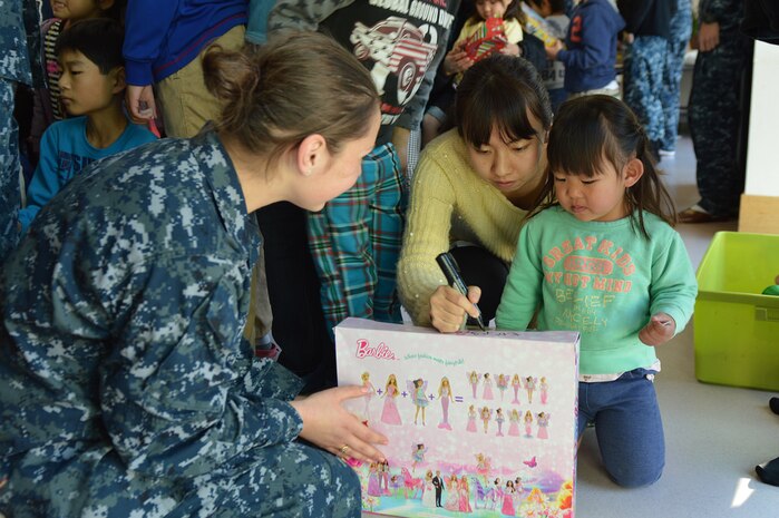 YOKOSUKA, Japan (Dec. 6, 2014) - Intelligence Specialist Seaman Amy Graham, from U.S. 7th Fleet flagship USS Blue Ridge (LCC 19), shares a gift with a local child from Shunkouen Spring Bright Garden Orphanage during a community relations (COMREL) event. Blue Ridge COMRELs strengthen relations promoting peace, stability and our commitment to our local communities. 141206-N-KG618-040
