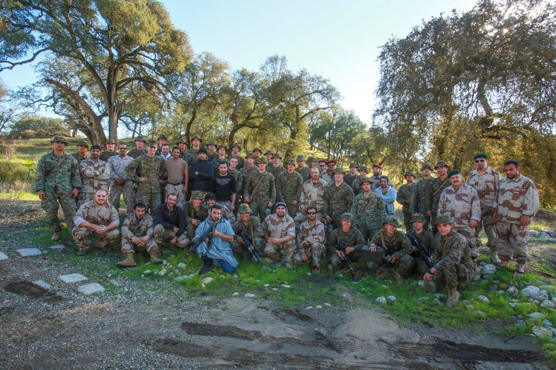 U.S. Marines with Battalion Landing Team 3rd Battalion, 1st Marine Regiment, 15th Marine Expeditionary Unit, and role-players pose for a group photo after participating in realistic urban training aboard Fort Hunter Liggett, Calif., Dec. 8, 2014. The Marines were simulating bi-lateral training exercises they could be tasked with while deployed. RUT prepares the 15th MEU's Marines for their upcoming deployment, enhancing their combat skills in environments similar to those they may find in future missions. (U.S. Marine Corps Photo by Sgt. Jamean Berry/Released)
