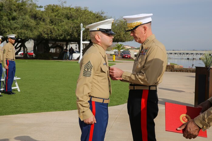General Joseph F. Dunford, 36th Commandant of the Marine Corps, awards Master Gunnery Sgt. Alain Reyes, recruiter instructor, Recruiting Station Salt Lake City, 12th Marine Corps District, Western Recruiting Region, with the Marine Corps Medal during the Superior Achiever Award Ceremony at the Admiral Kidd Conference Center, Naval Base Point Loma, San Diego, Dec. 5.  Reyes was awarded for his heroic actions during an active shooter incident in his local community.