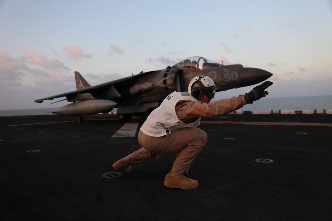 Col. Matthew G. Trollinger, commanding officer, 11th Marine Expeditionary Unit (MEU), signals for an AV-8B Harrier to launch off the flight deck of the amphibious assault ship USS Makin Island (LHD 8), Dec. 4. The Makin Island Amphibious Ready Group (ARG), and the embarked 11th MEU are deployed in support of maritime security operations and theater security cooperation efforts in the U.S. 5th Fleet area of responsibility. (U.S. Marine Corps photos by Cpl. Demetrius Morgan/Released)  