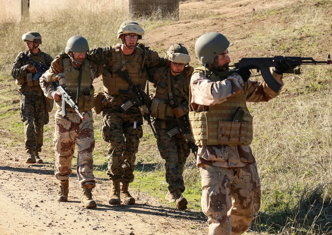 U.S. Marines with Battalion Landing Team 3rd Battalion, 1st Marine Regiment, 15th Marine Expeditionary Unit, and role-players evacuate a simulated casualty while participating in realistic urban training aboard Fort Hunter Liggett, Calif., Dec. 8, 2014. The Marines were simulating bi-lateral training exercises they could be tasked with while deployed. RUT prepares the 15th MEU's Marines for their upcoming deployment, enhancing their combat skills in environments similar to those they may find in future missions. (U.S. Marine Corps Photo by Sgt. Jamean Berry/Released)