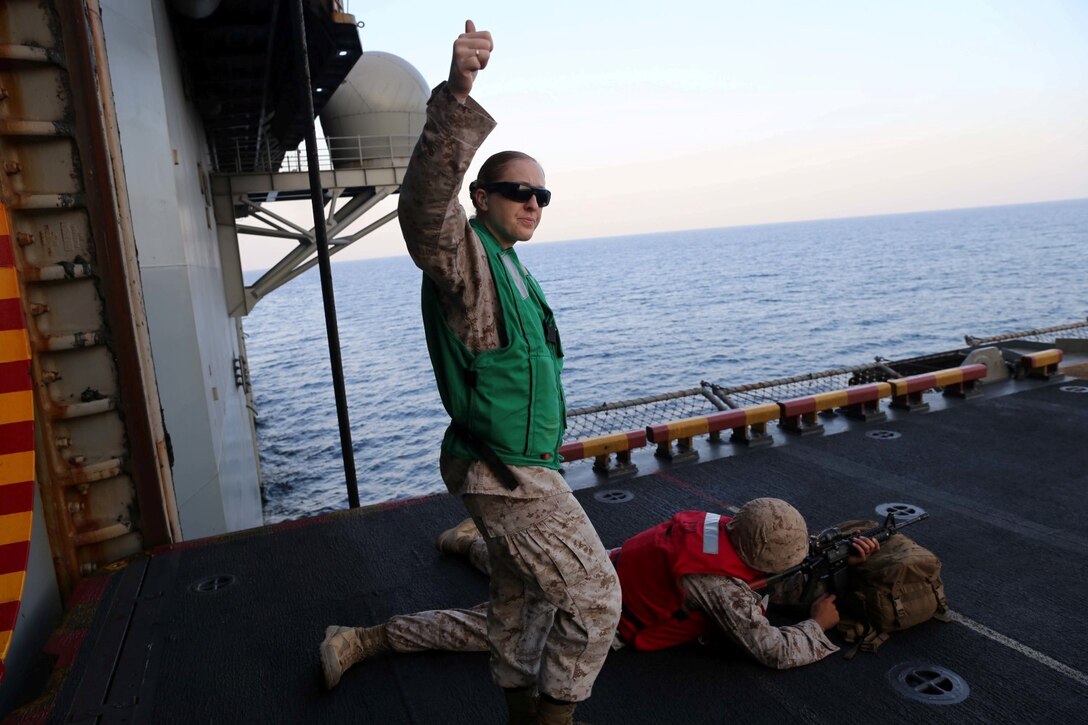 Staff Sgt. Samantha Shepard, a motor transport operations chief with Combat Logistics Battalion 11, 11th Marine Expeditionary Unit (MEU), signals to the range safety officer during a live-fire range aboard the amphibious assault ship USS Makin Island (LHD 8), Dec. 5. The Makin Island Amphibious Ready Group (ARG) and the embarked 11th MEU are deployed in support of maritime security operations and theater security cooperation efforts in the U.S. 5th Fleet area of responsibility. (U.S. Marine Corps photos by Cpl. Demetrius Morgan/Released)