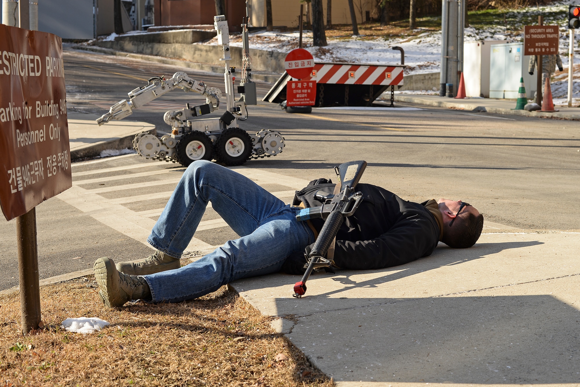 A person with a simulated IED lays prostrate as an Explosive Ordnance Disposal robot approaches during exercise Beverly Bulldog 15-01 Dec. 9, 2014, at Osan Air Base, Republic of Korea. Beverly Bulldog 15-1 is a peninsula-wide ORE designed to test American forces mission readiness in the event of an emergency or wartime environment. (U.S. Air Force photo by Staff Sgt. Jake Barreiro)