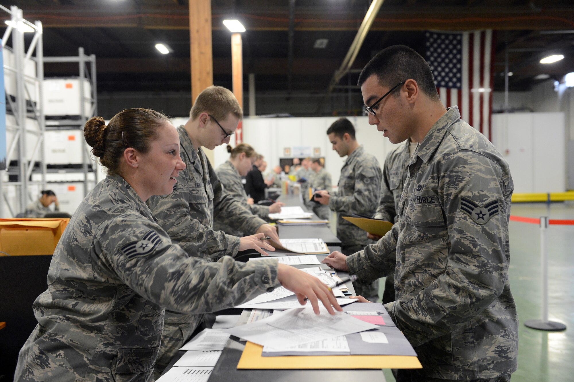 Staff Sgt. Heather Wagnon (left), 627th Force Support Squadron IPR NCO in charge, explains a deployment checklist with Senior Airman Roland Pryor, 62nd Aircraft Maintenance Squadron crew chief, Dec. 9, 2014, during a deployment processing line at Joint Base Lewis-McChord, Wash. The IPR section is one of the last agencies deploying Airmen coordinate with before their deployment. (U.S. Air Force photo/Airman 1st Class Keoni Chavarria)