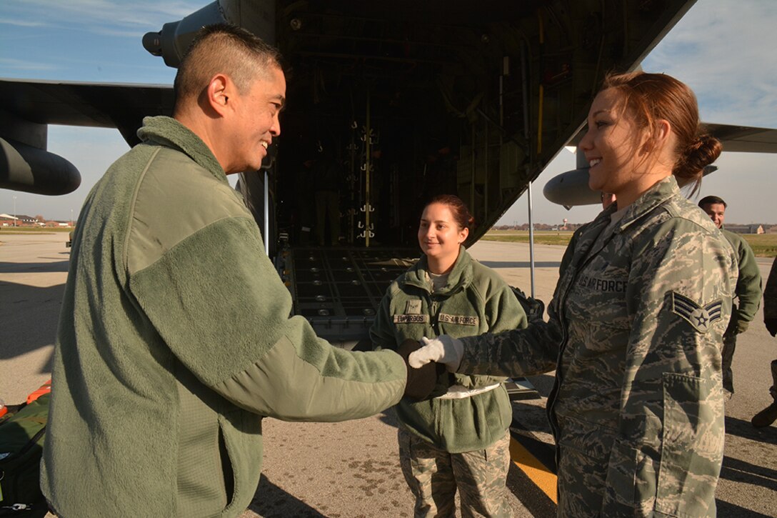 Chief Master Sergeant Brian Wong, Command Chief Master Sergeant, Fourth Air Force, talks about training on the flight line while shaking hands with Senior Airman Erica Buerk from the 932nd Aeromedical Staging Squadron, 932nd Medical Group, during a visit to the 932nd Airlift Wing. This was Chief Wong's first visit to Scott Air Force Base. Fourth Air Force has command supervision of the Air Force Reserve's long-range airlift and air-refueling units located throughout the continental United States, Hawaii and Guam. (U.S. Air Force Photo/ Staff Sgt. Amber Hodges) 



