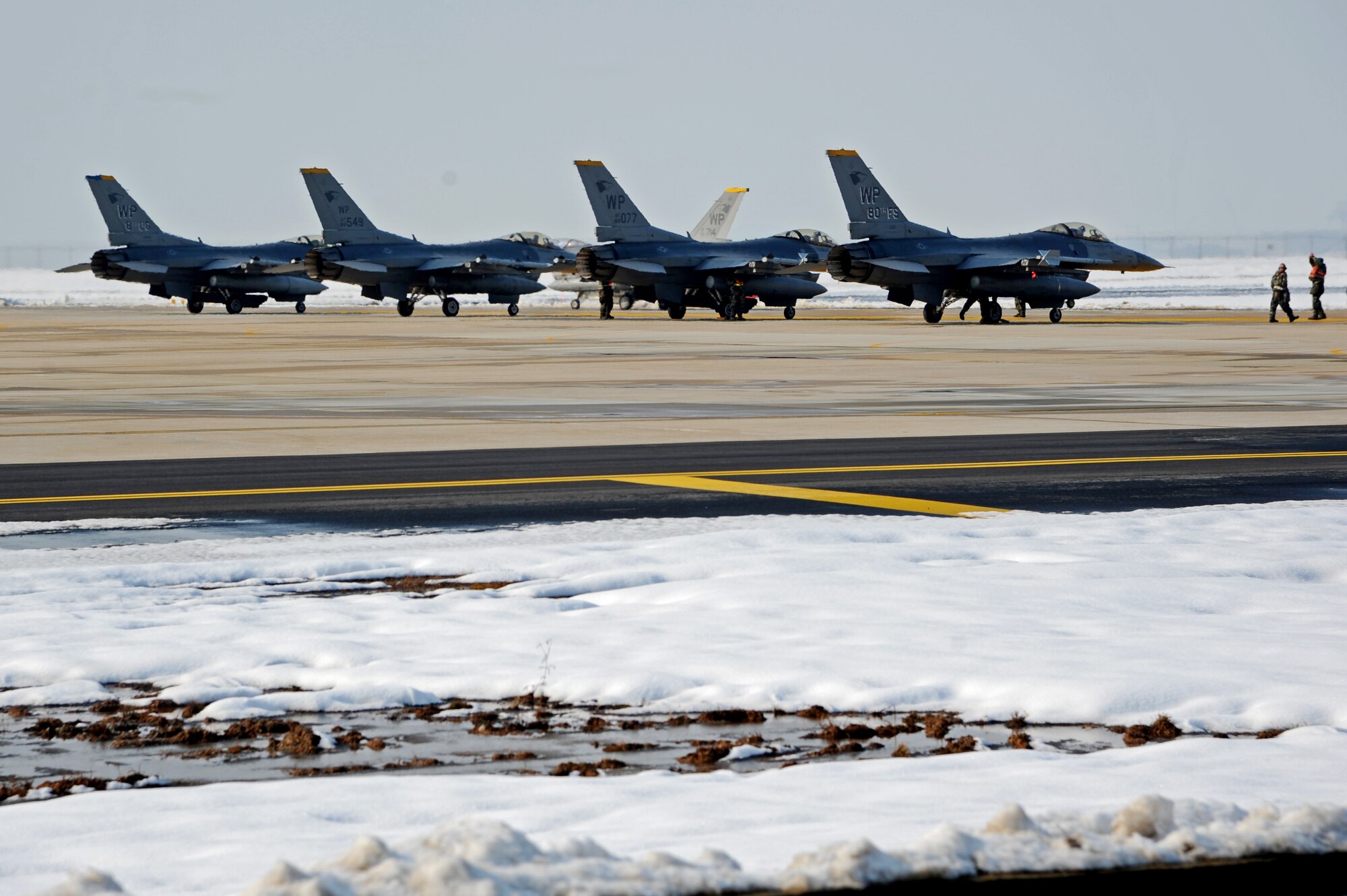 F-16 Fighting Falcons return from a flight during Exercise Beverly Bulldog 15-1 at Kunsan Air Base, Republic of Korea, Dec. 8, 2014. The eight-day exercise took place in an austere environment that tested the Wolf Pack’s ability to respond to wartime and armistice threats, and showcased their ability to persevere through extreme temperatures and more than eight inches of snow. (U.S. Air Force photo by Senior Airman Divine Cox/Released)