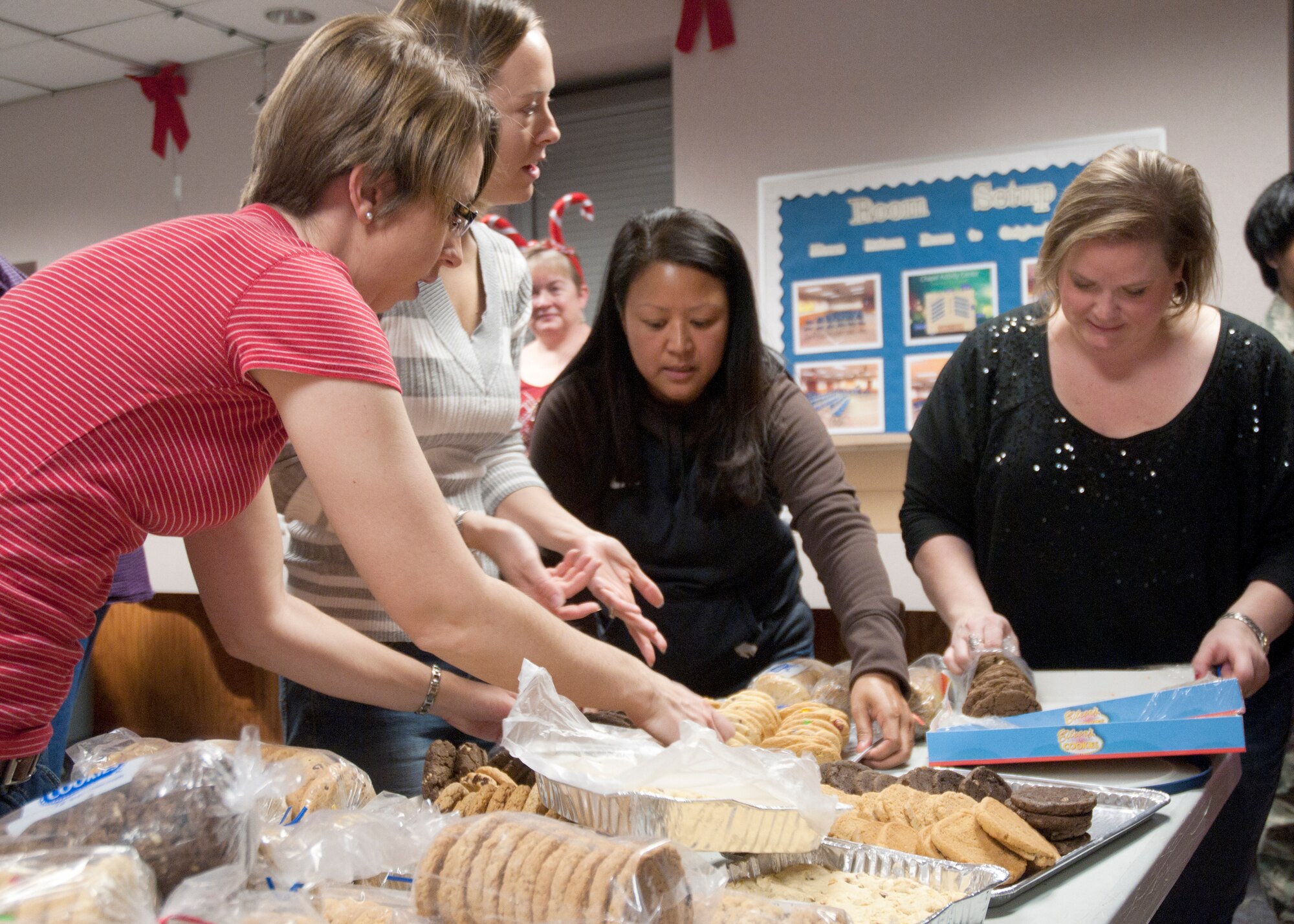 Military spouses Jessica Martin, Jenna Karr, Gina Moriarty and Vanesse Couch organize cookies during the wing’s cookie drive Dec. 8, 2014, in the Chapel Activities Center on F.E. Warren Air Force Base, Wyo. The local Air Force Association in Cheyenne, Wyo., donated 6,000 cookies along with additional cookies from various families and Airmen. (U.S. Air Force photo/Airman 1st Class Malcolm Mayfield)
