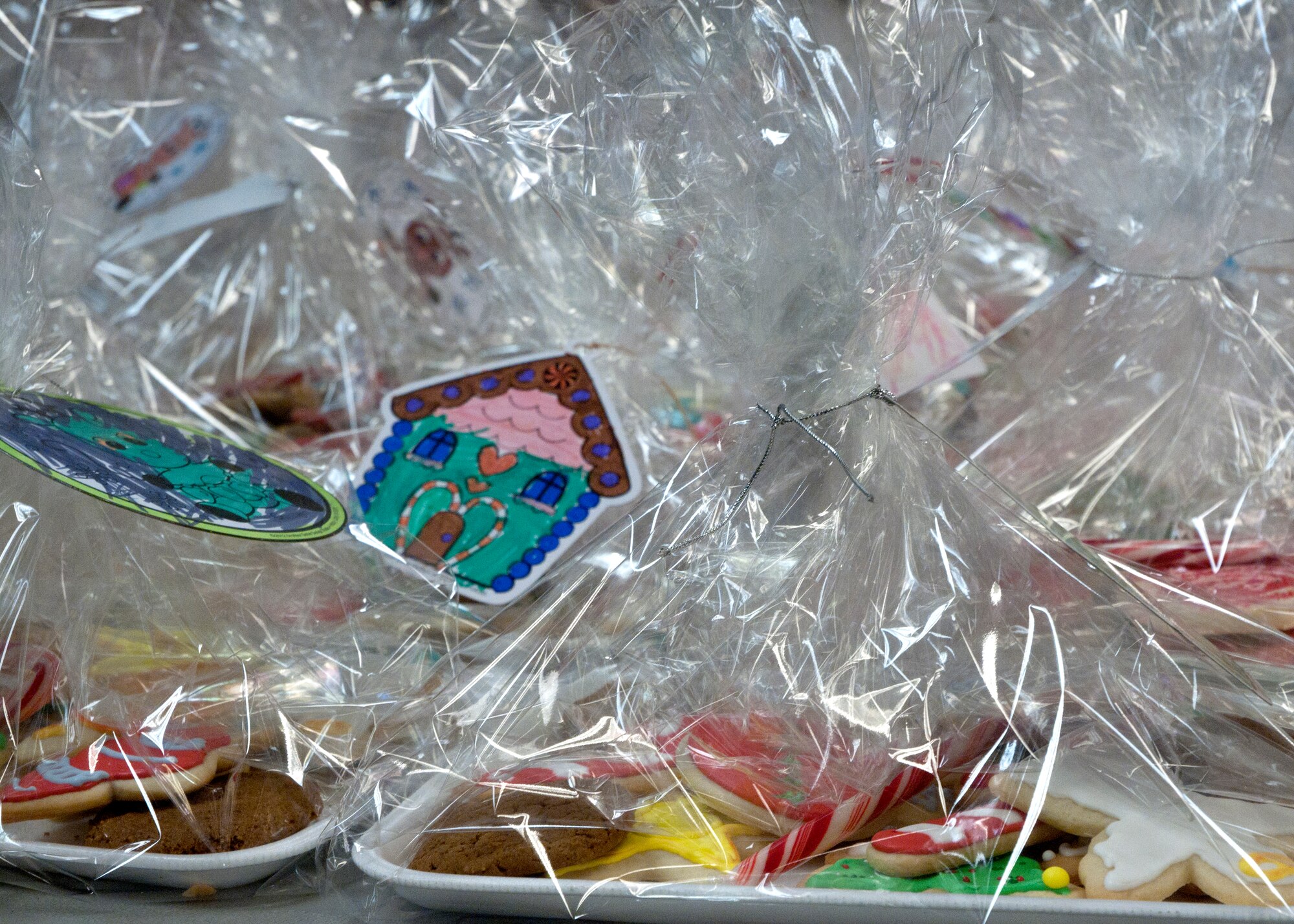 Cookies packaged for distribution wait on a table Dec. 8, 2014, in the Chapel Activities Center on F.E. Warren Air Force Base, Wyo. Children from Freedom Elementary, Cheyenne, Wyo., and those home schooled on base made and donated the decorative ornaments used in the packaging of some of the cookies. (U.S. Air Force photo/Airman 1st Class Malcolm Mayfield)