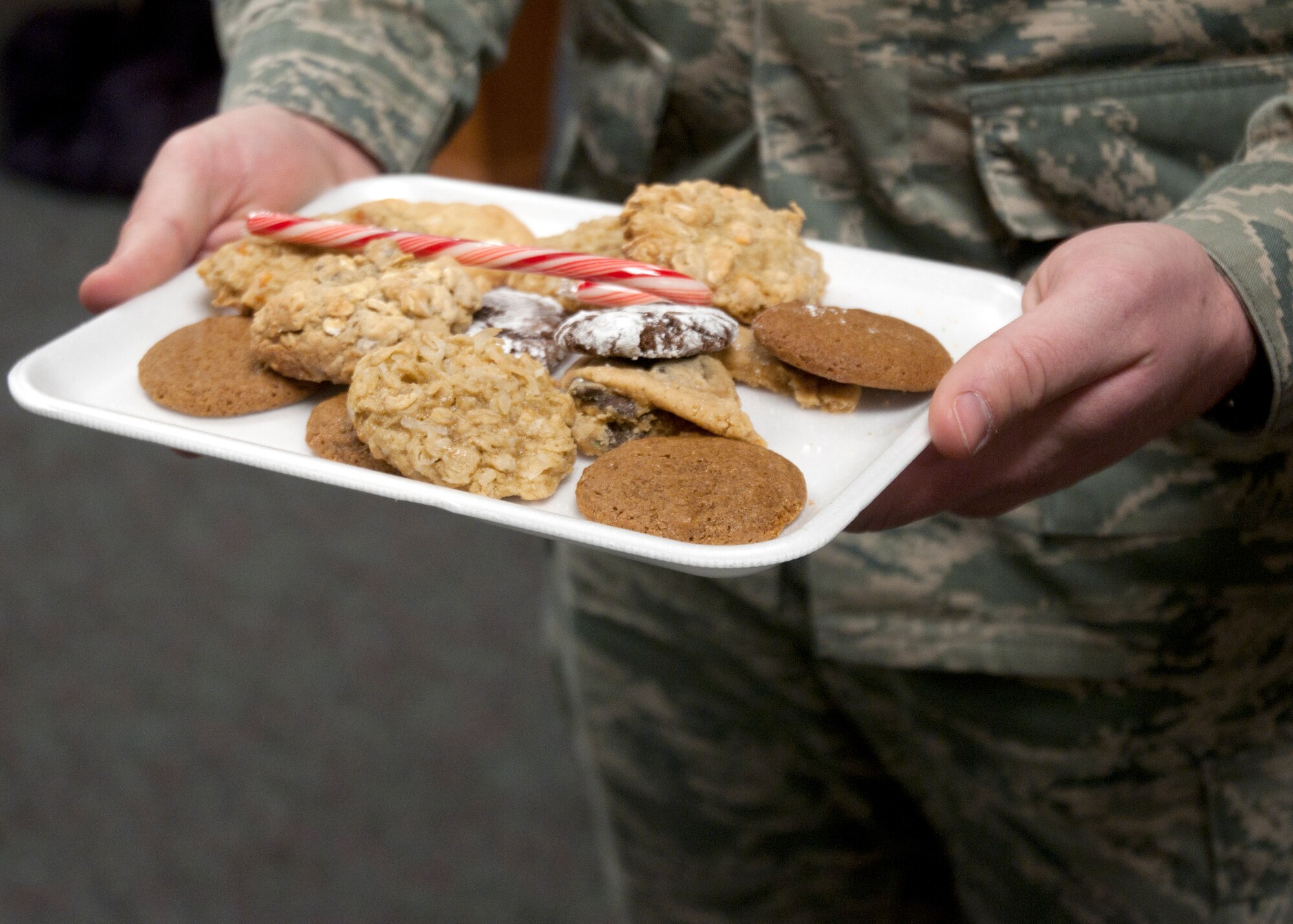 An Airman holds a tray of cookies made during a cookie drive Dec. 8, 2014, in the Chapel Activities Center on F.E. Warren Air Force Base, Wyo. Mike Hayes, spouse of Col. Tracey Hayes, 90th Missile Wing commander, participated and organized the wing cookie drive.` (U.S. Air Force photo/Airman 1st Class Malcolm Mayfield)