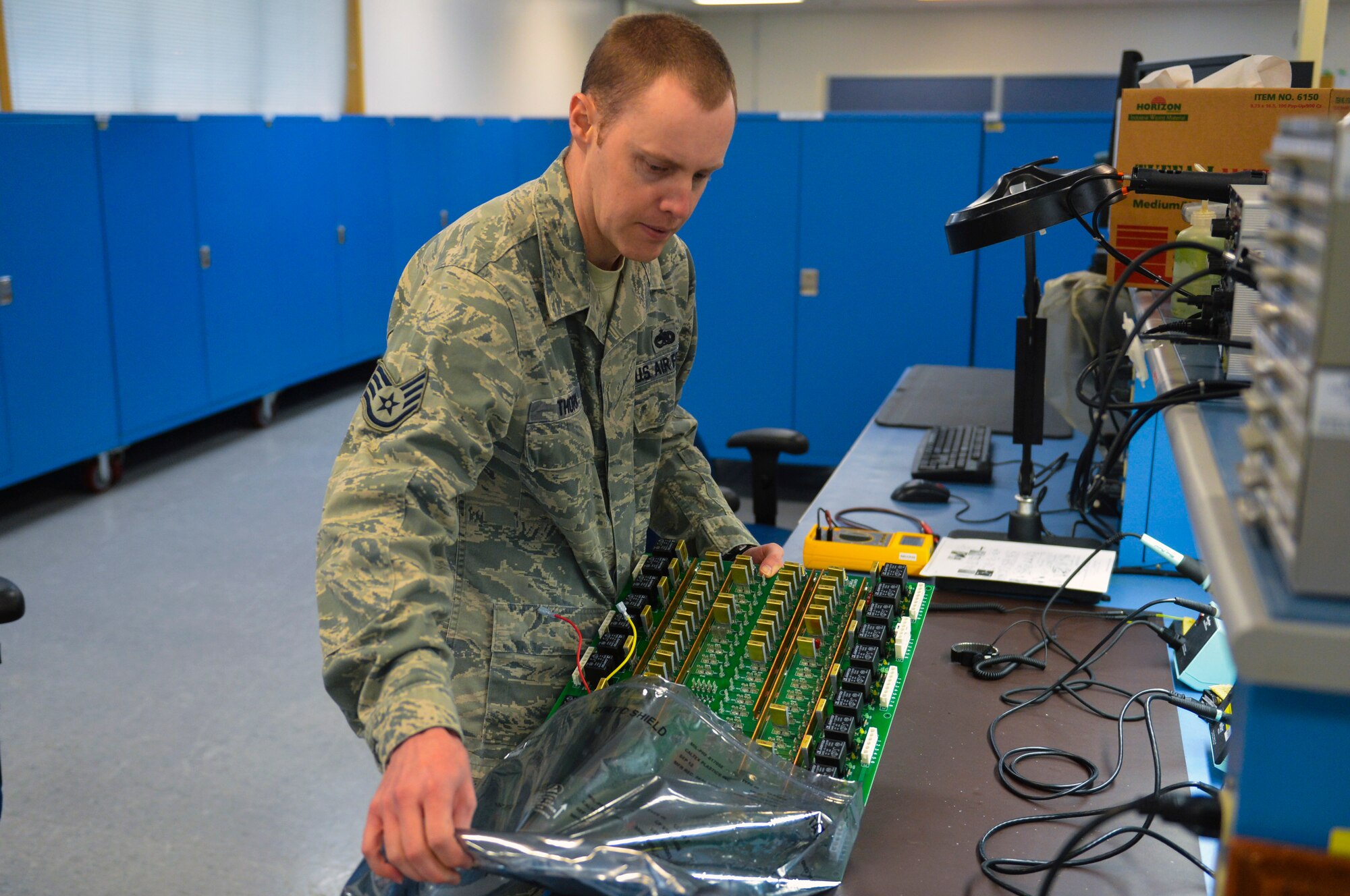 Staff Sgt. Jesse Thorn 62nd Maintenance Squadron intermediate section craftsman, removes a circuit card from its packaging for a McChord Field Airport Rescue Fire Fighting truck Dec. 9, 2014 at Joint Base Lewis-McChord, Wash. Thorn and Airmen from both the fire truck maintenance shop and the avionics shop worked together to find a solution of great ingenuity which will save the Air Force $3,000 every time the problem arises. (U.S. Air Force photo/Staff Sgt. Russ Jackson)