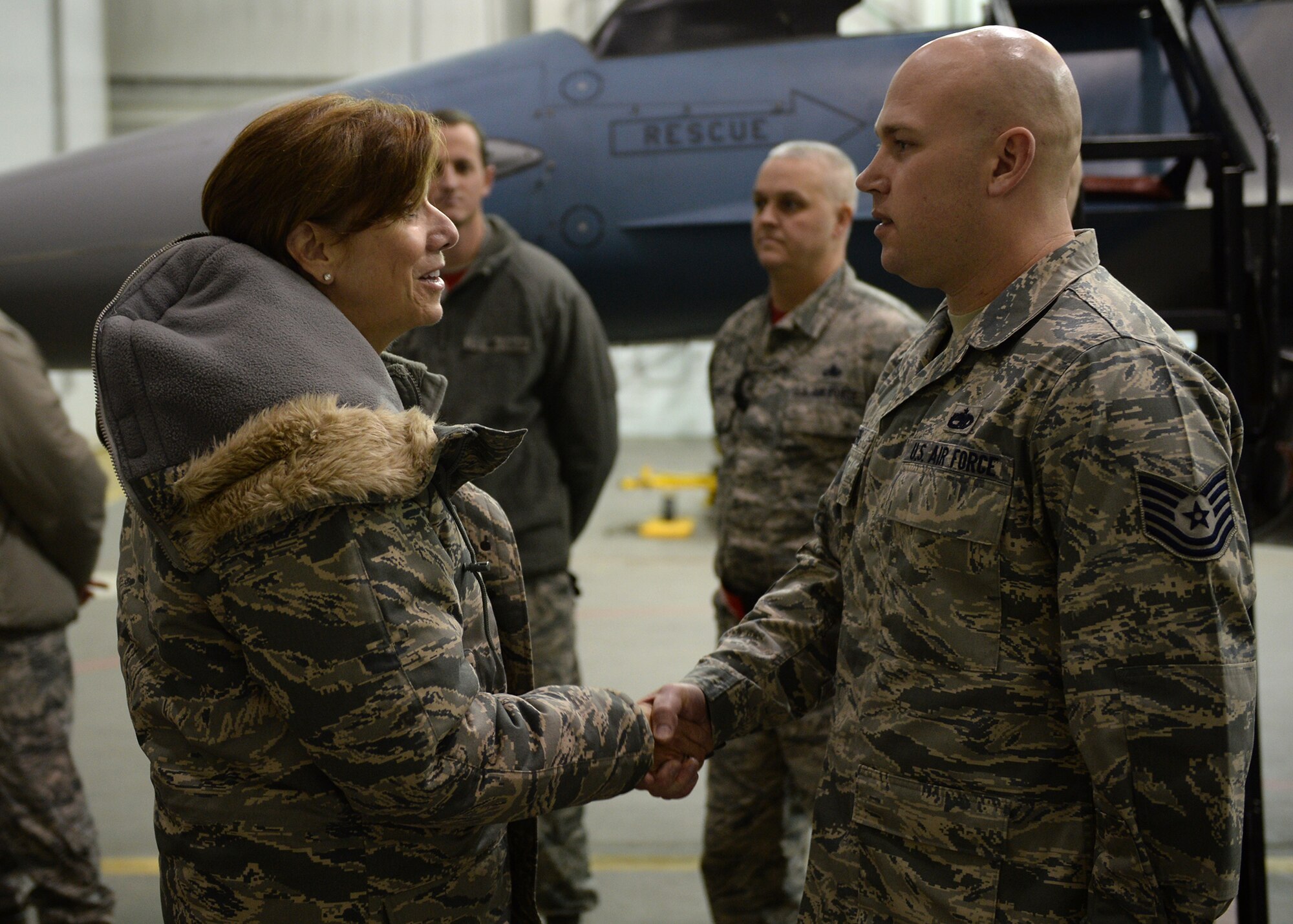U.S. Air Force Gen. Lori Robinson, the Pacific Air Forces commander, coins Tech. Sgt. Ian Neske, an avionics section chief assigned to the 354th Maintenance Squadron, during her visit at Eielson Air Force Base, Alaska, Dec. 5, 2014. Gen. Robinson, along with Chief Master Sgt. Buddy Hutchison, the PACAF command chief, visited with Airmen and families and got to see first-hand how Eielson Airmen execute the Air Force mission. (U.S. Air Force photo by Staff Sgt. Shawn Nickel/Released)