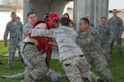 Staff Sgt. Scott Mellott, 902nd Security Forces Squadron NCO in charge of plans, plays the role of an active shooter during a Counter Active Shooter Tactics class while three members of the 902nd SFS Squadron attempt to subdue him Dec. 8 at Joint Base San Antonio-Randolph. Members of the 502nd Air Base Wing at JBSA-Randolph broke from daily operations and missions to reinforce the Wingman concept and provide a foundation for building resilient Airmen with team building exercises in the form of a sporting, recreational, and process improvement events. (U.S. Air Force photo by Johnny Saldivar)
