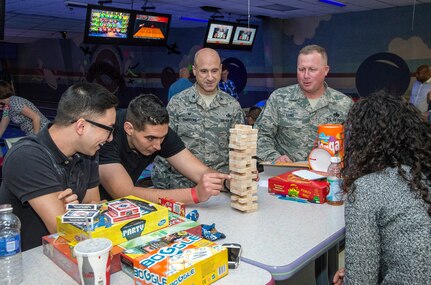 Senior Airman Gabriel Svectos (left), Senior Airman William Underhill and Senior Airman Natalie Parraghi (right), 502nd Contracting Squadron contract administrators, compete in a game Dec. 8 at Joint Base San Antonio-Randolph’s bowling center. Members of the 502nd Air Base Wing at JBSA-Randolph broke from daily operations and missions to reinforce the Wingman concept and provide a foundation for building resilient Airmen with team building exercises in the form of a sporting, recreational, and process improvement events. Col. Michael Gimbrone, 502nd Security Forces and Logistics Support Group commander, and Chief Master Sergeant Martin Lund, 502nd Security Forces and Logistics Support Group superintendent, observe the Airmen play the game. (U.S. Air Force photo by Johnny Saldivar)