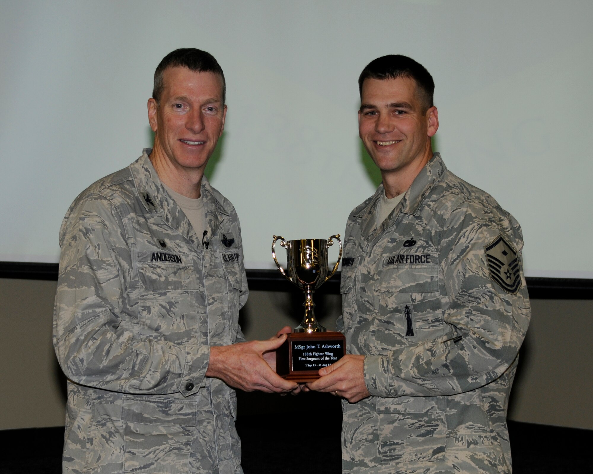 Col. Mark Anderson, 188th Wing commander, presents the 188th First Sergeant of the Year award to Master Sgt. John Ashworth during a commander’s call presentation at Ebbing Air National Guard Base, Fort Smith, Ark., Dec. 7, 2014. Ashworth is assigned to the 188th Medical Group. (U.S. Air National Guard photo by Staff Sgt. John Suleski/Released)