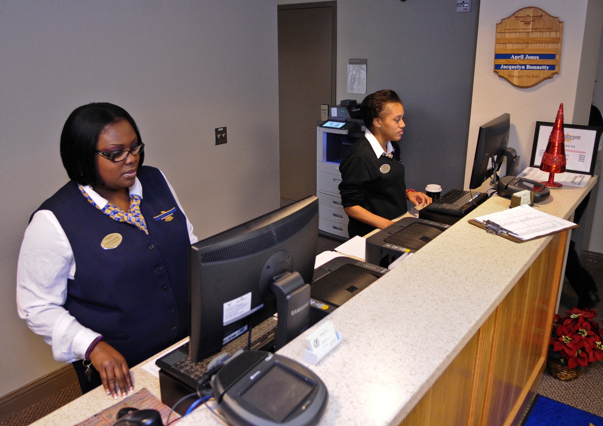 Ietrice Porter and April Jones, 2nd Force Support Squadron guest services representatives, check arrivals and departures for the day at the Barksdale Inn on Barksdale Air Force Base, La., Dec. 9, 2014. More than 50 staff members, both military and civilian, help to provide comfort and security to travelling service members and their families 24 hours a day, seven days a week. (U.S. Air Force photo/Senior Airman Kristin High)