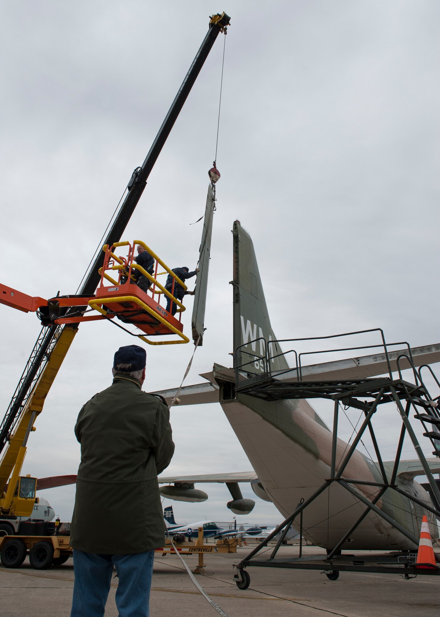 Tom Galish, restoration volunteer, from the ground guides the detached rudder from a C-123K Provider cargo aircraft Nov. 13, 2014, at the Air Mobility Command Museum, on Dover Air Force Base Del. All of the museum’s aircraft receive regular maintenance and restoration if needed to ensure their historic integrity. (U.S. Air Force photo/Airman 1st Class Zachary Cacicia)  