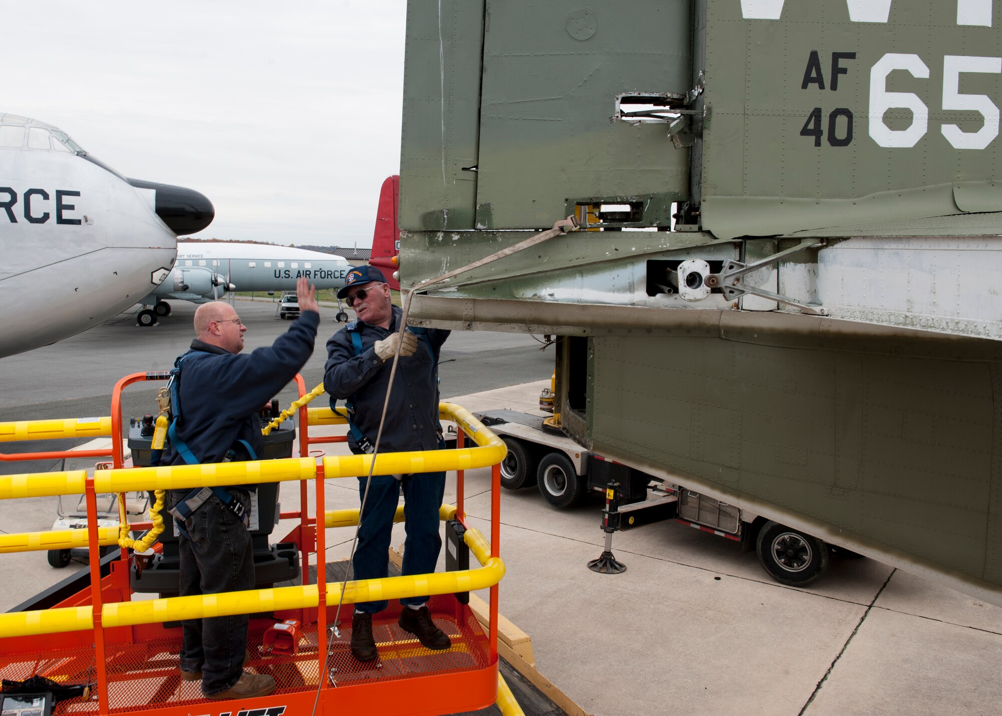 Leslie Polley, restoration manager, left, and Gene Somma, restoration volunteer, detach a rudder from the vertical stabilizer of a C-123K Provider cargo aircraft Nov. 13, 2014, at the Air Mobility Command Museum, on Dover Air Force Base, Del. The rudder was removed to perform restoration work on the aircraft. (U.S. Air Force photo/Airman 1st Class Zachary Cacicia)