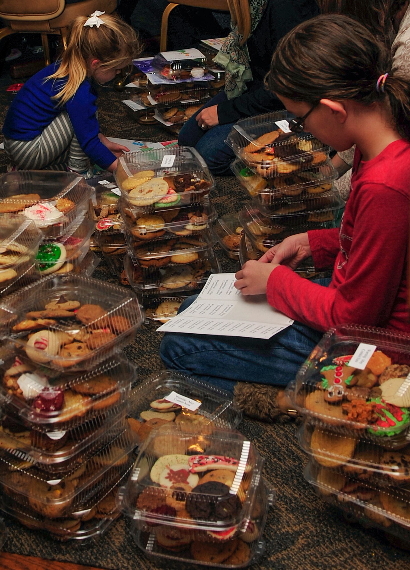 Kids place stickers on the packages of cookies and baked goods in support of the Airmen Cookie Drive at Seymour Johnson Air Force Base, North Carolina, Dec. 8, 2014. Members of Team Seymour and the community donated more than 14,000 cookies and baked goods, shattering the goal of 8,000. [The Officer and Civilian Spouses’ Club is a private organization. It’s not a part of the Department of Defense or any of its components and has no governmental status.] (U.S. Air Force photo/Airman Shawna L. Keyes)
