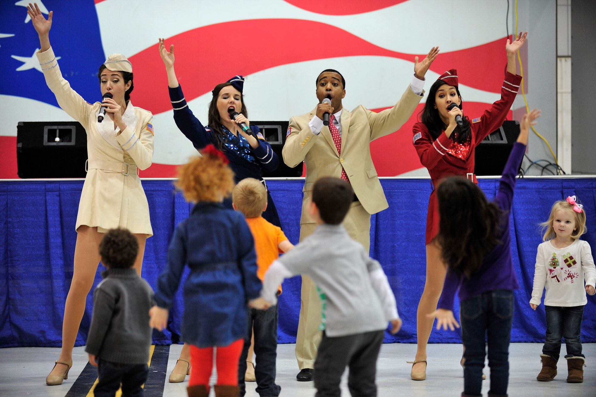 Performers from the United Service Organization Show Troupe sing during a performance at Seymour Johnson Air Force Base, North Carolina, Dec. 6, 2014. The Show Troupe, made up of four singers and a support team, provided an hour-long set for members of Team Seymour. They annually perform musical entertainment for more than 600,000 service members and families across the globe. (U.S. Air Force photo/Amn Shawna L. Keyes)