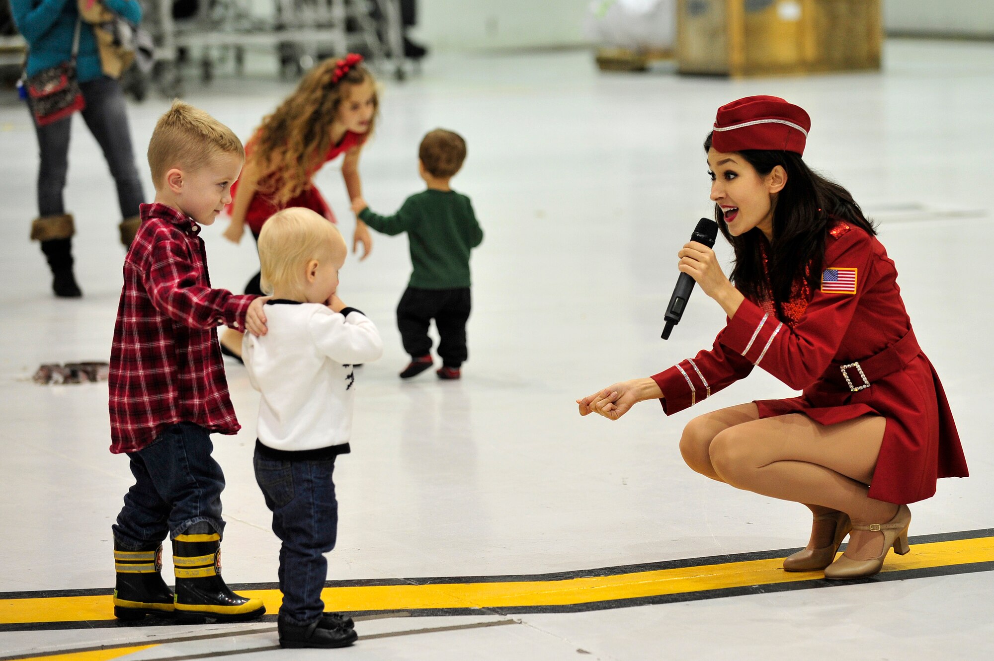 Bryna O’Neill, United Service Organization Show Troupe performer, sings to young members of Team Seymour during a performance at Seymour Johnson Air Force Base, North Carolina, Dec. 6, 2014. The Show Troupe, made up of four singers and a support team, provided an hour-long set for members of Team Seymour. They annually perform musical entertainment for more than 600,000 service members and families across the globe. (U.S. Air Force photo/Amn Shawna L. Keyes)