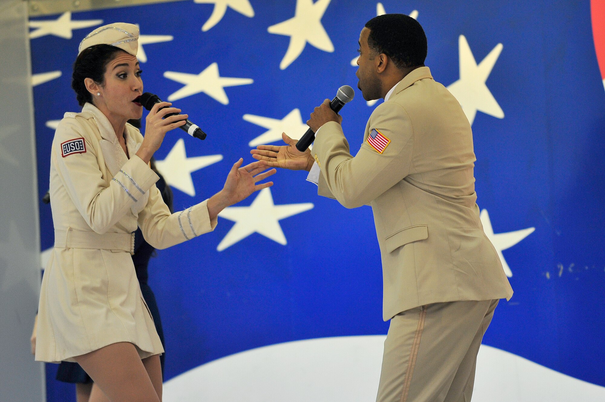 Kimberly Thomas (left) and Jeremy Gaston, United Service Organization Show Troupe singers, perform a duet during a performance at Seymour Johnson Air Force Base, North Carolina, Dec. 6, 2014. The Show Troupe, made up of four singers and a support team, provided an hour-long set for members of Team Seymour. They annually perform musical entertainment for more than 600,000 service members and families across the globe. (U.S. Air Force photo/Amn Shawna L. Keyes)