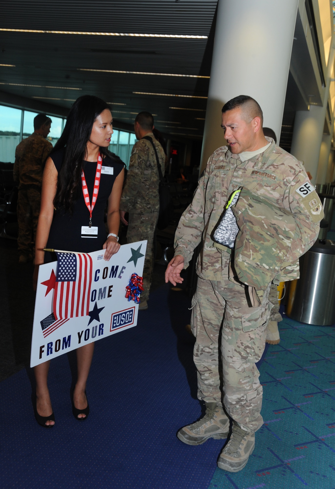 Christine Vu from the Portland USO talks with Staff Sgt. Joseph Cubias from the 142nd Security Forces Squadron after he and five other Airmen returned from their OEF deployment to Portland, Ore., Oct. 31, 2014.  (U.S. Air National Guard photo by Tech. Sgt. John Hughel, 142nd Fighter Wing Public Affairs/Released)