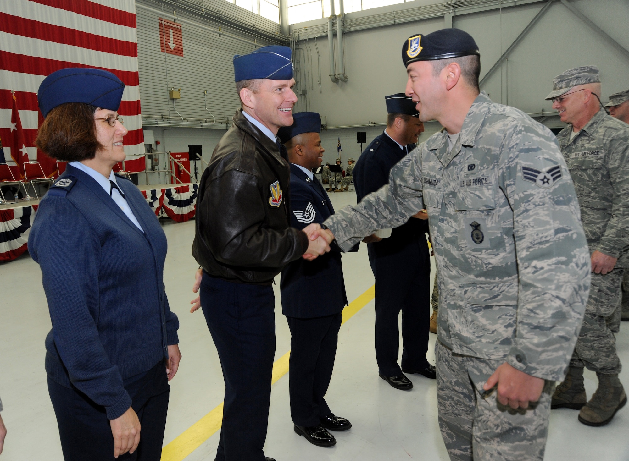 Col. Rick Wedan, 142nd Fighter Wing Commander, center left, along with Chief Master Sgt. Julie Eddings, 142nd Fighter Wing Command Chief, left, greet Airmen from the 142nd Fighter Wing Civil Engineer Squadron and Security Forces Squadron after the formal Demobilization Ceremony at the Portland Air National Guard Base, Ore., Dec. 7, 2014. (U.S. Air National Guard photo by Tech. Sgt. John Hughel, 142nd Fighter Wing Public Affairs/Released)